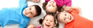 four children smiling on the ground